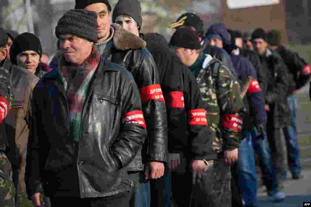 Участники так называемой крымской самообороны выстраиваются на площади перед памятником Ленина в Симферополе, 14 марта 