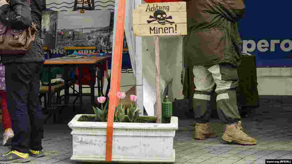 Табличка «Осторожно – мины!» возле макета противопехотной мины