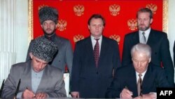 Ахмед Закаев (крайний справа, стоит) во время подписания Договора о мире и принципах взаимоотношений между РФ и ЧРИ