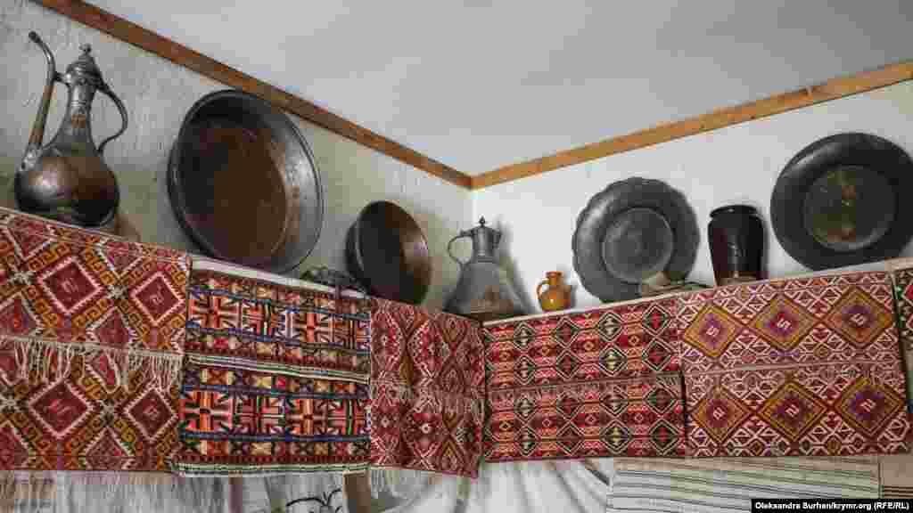 Кімната прикрашена тканинами з домотканими вишивками. Такі вишивки кримськотатарська дівчина готувала собі, як придане. На полицях стоїть мідний посуд, в тому числі «гугуми» –  це посуд, з якими за старих часів ходили до фонтану по воду