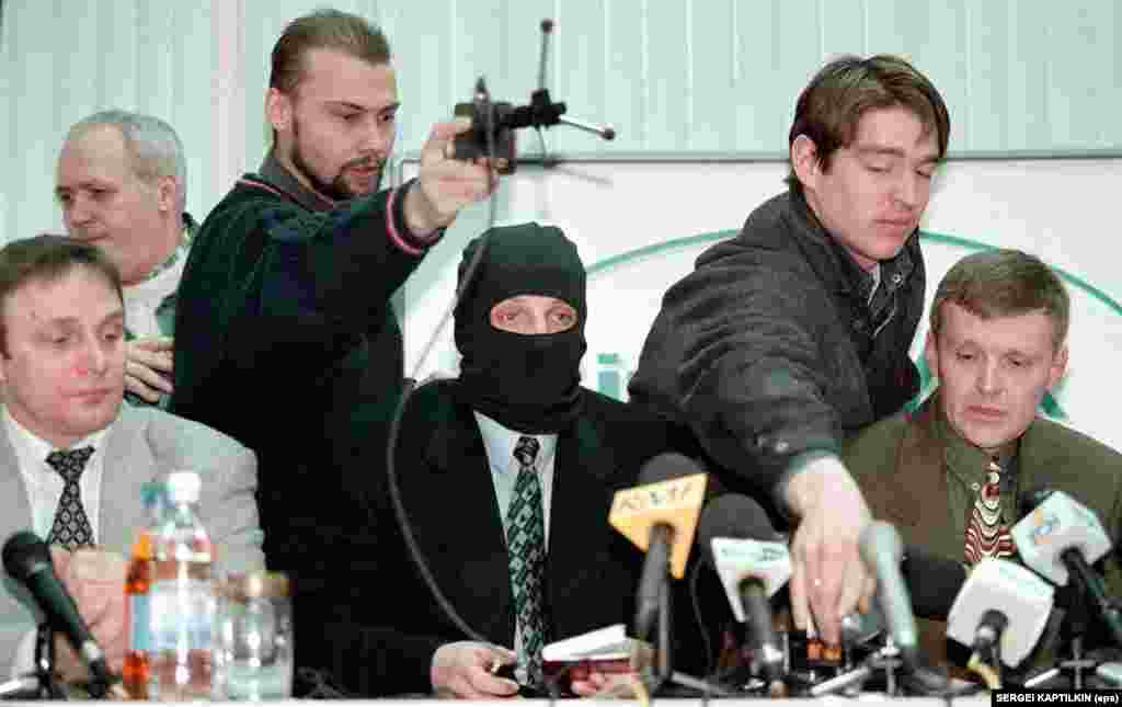 Journalists prepare microphones for a press conference by officers of the Russian Federal Security Service (FSB) at the Interfax news agency in Moscow on November 17, 1998. Former agent Mikhail Trepashkin (seated left), a colleague wearing a mask to protect his identity (center), and Litvinenko (right) accused their FSB commanding officers of ordering kidnappings and assassinations, including an attempt to kill billionaire businessman and power broker Boris Berezovsky. 
