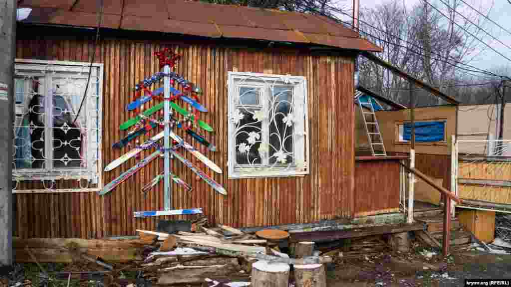 Новогодняя лыжная «елка» на стене старой сторожки турбазы 