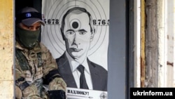 Боец Территориальной обороны Украины и мишень с изображением президента России Владимира Путина во время военной подготовки недалеко от Киева, 20 мая 2022 года