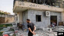 A man checks a house that was hit by a Hizballah rocket in Kiryat Shmona, near the Lebanese border in northern Israel, late last month.
