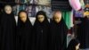 Mannequins dressed in chadors are displayed in a shop in front of a shrine at the city of Qom.