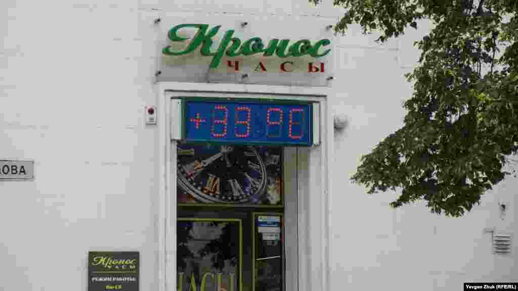 Табло магазина показывает температуру воздуха +33° по Цельсию