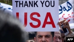 Иракский христианин поднимает плакат с благодарностью в адрес США на демонстрации у американского консульства в Ириби (один из центров населенной курдами области). Август 2014 года.