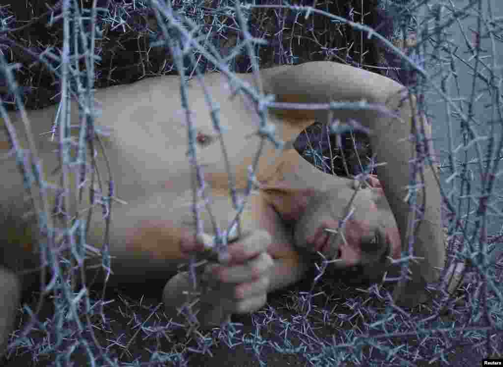 Pavlensky lies on the ground wrapped in barbed wire during a protest action in St. Petersburg in May 2013 to condemn the prosecution of punk collective Pussy Riot.