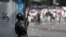 Боец Национальной боливарианской гвардии Венесуэлы напротив оппозиционных демонстрантов. Каракас, 23 января
