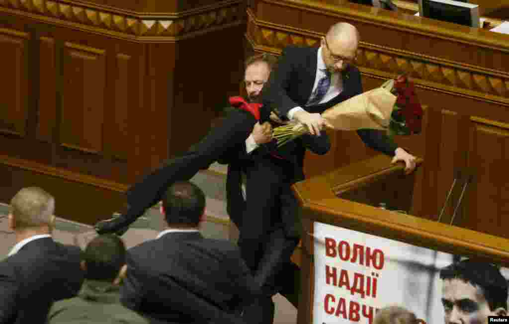 Депутат Верховной Рады Олег Барна пытается стащить Арсения Яценюка с трибуны. 11 декабря 2015 года.  
