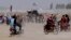PAKISTAN -- Supporters of the Taliban carry the Taliban's signature white flags in the Afghan-Pakistan border town of Chaman, Pakistan, Wednesday, July 14, 2021.