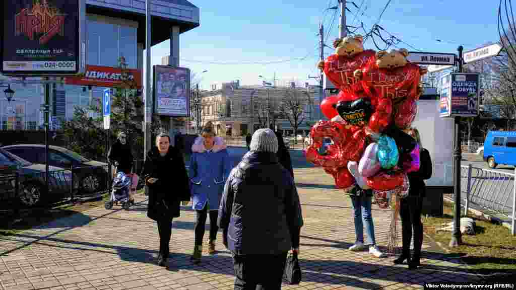 Девушка продает воздушные шары. Средняя цена одного шара в виде сердца составляет 200 рублей (80 грн)